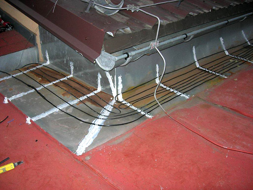 Topné kabely pro vyhřívání úžlabí střechy, kde se před instalací zadržoval led a sníh trhající okapové svody